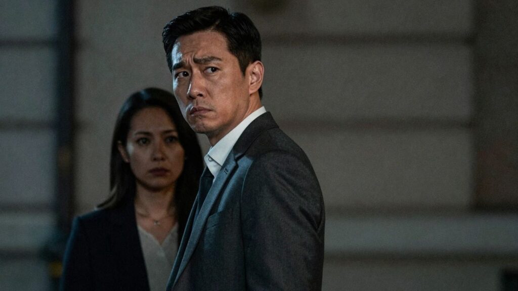 Man looking back at a shadowy second woman.