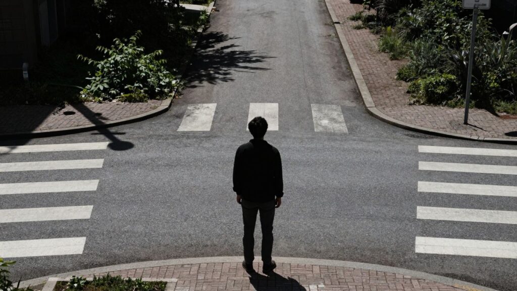 Person at a crossroads, facing a choice.