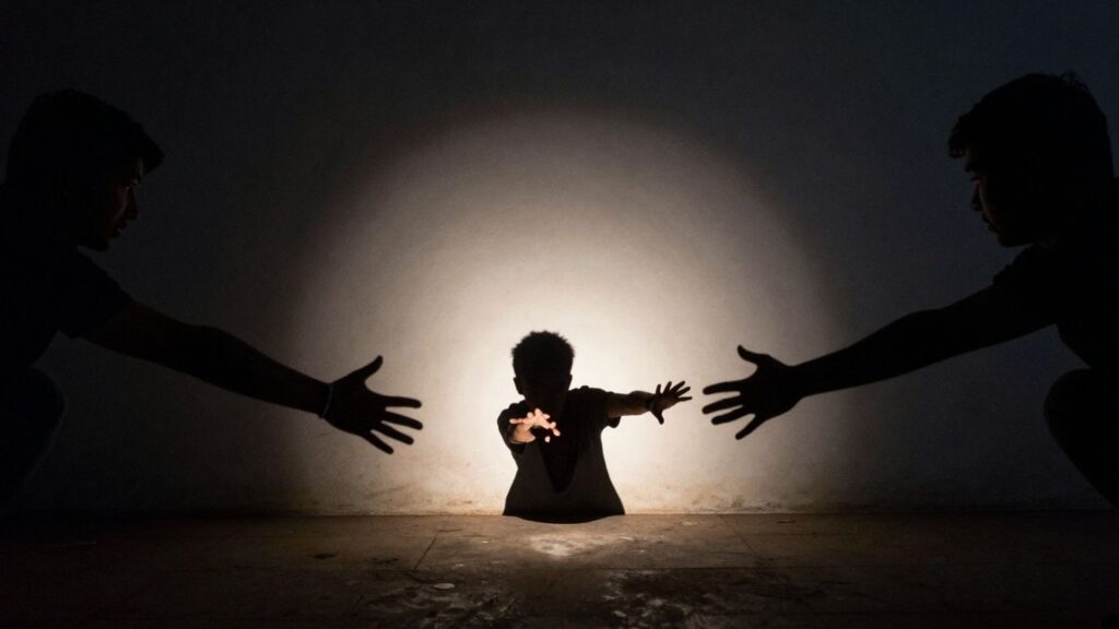 Person stepping out of shadows into a spotlight.