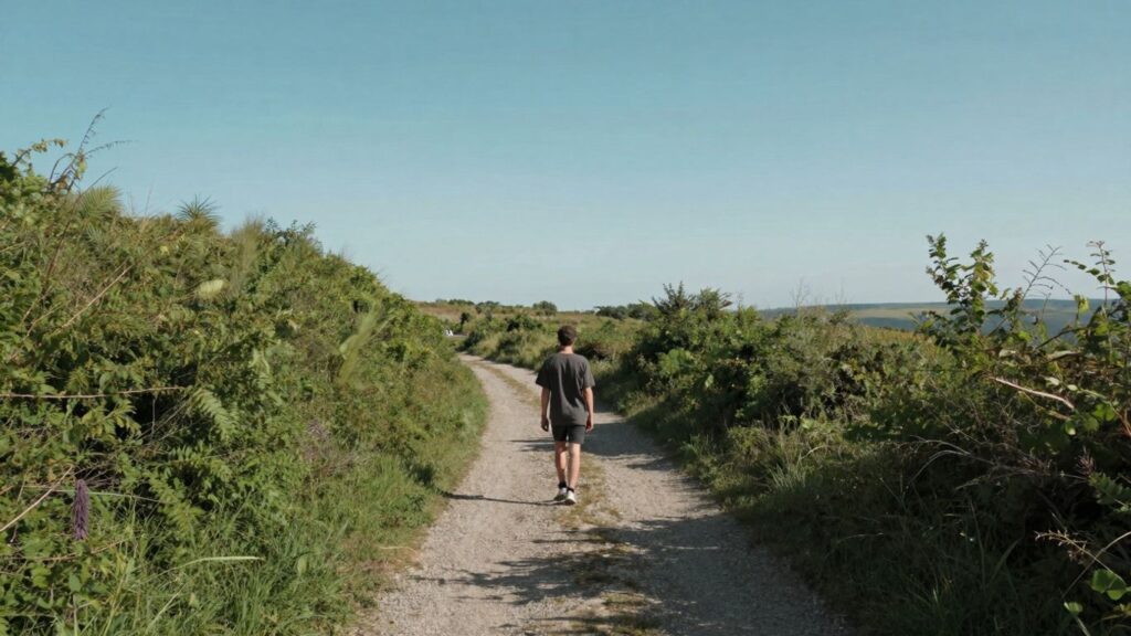Calm person on a path towards a bright horizon.