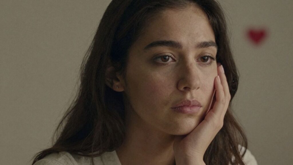 Woman looking thoughtful, hand on cheek, warm lighting.