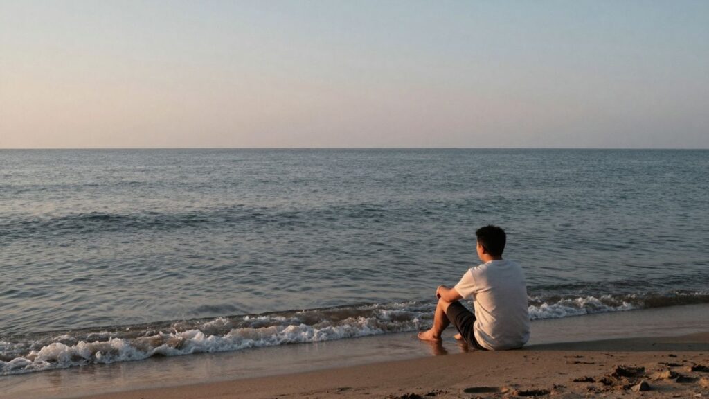 Calm figure by serene water under pastel sky.