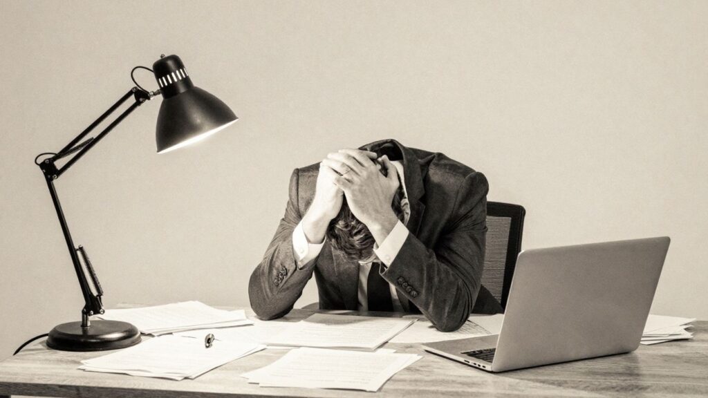 Exhausted man overwhelmed by work.