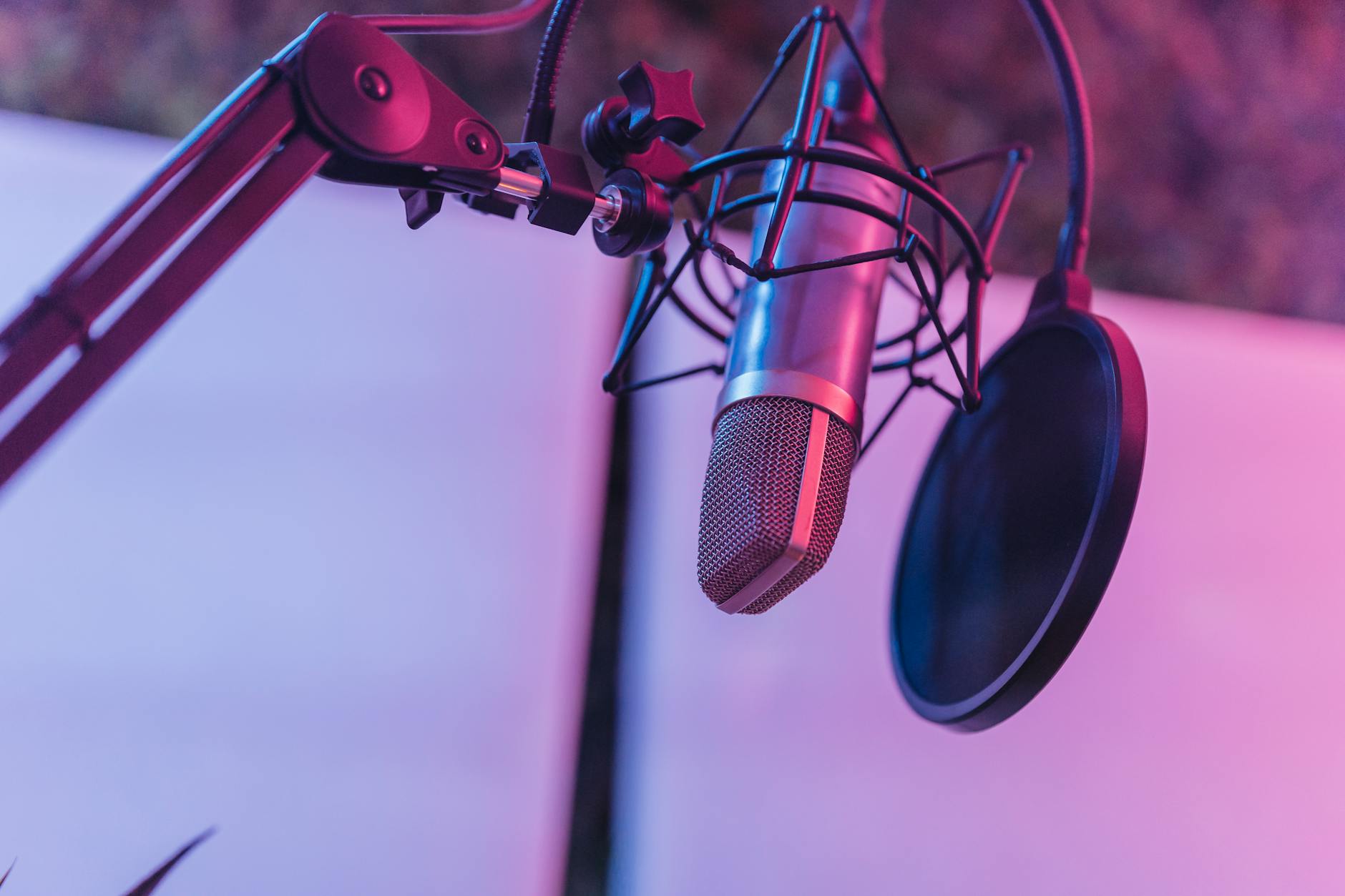 Podcast studio microphone in vibrant pink lighting - Alex Cooper Call Her Daddy