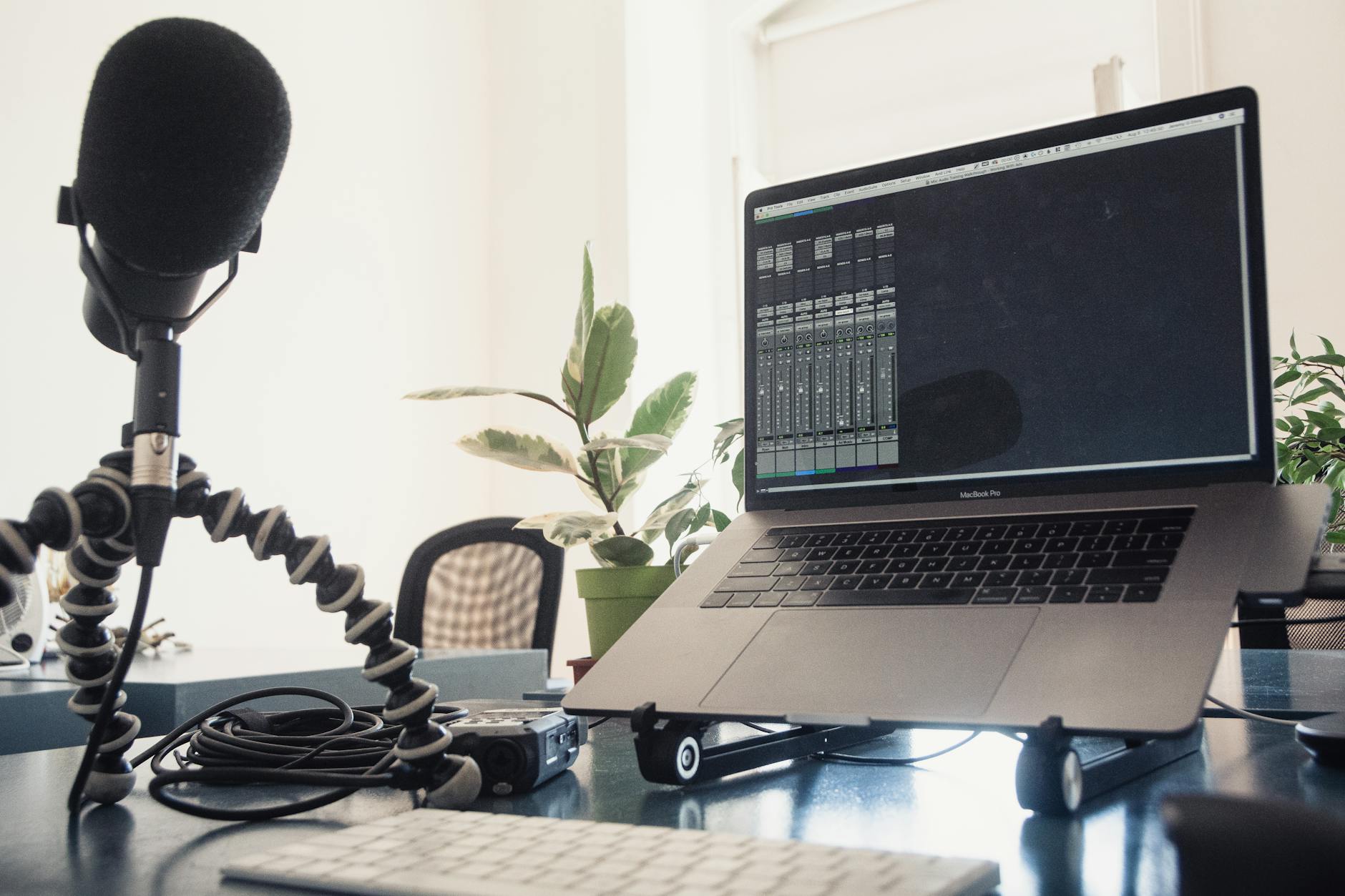 Detailed studio setup featuring a laptop and microphone on a desk for audio production