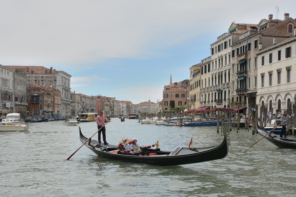 A gondolier rowing a gondola with passengers on the Grand Canal in Venice