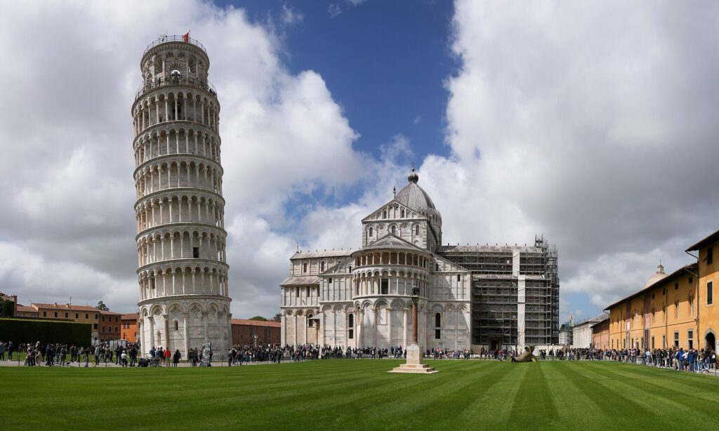 The Leaning Tower of Pisa and Pisa Cathedral on Piazza dei Miracoli under a blue sky