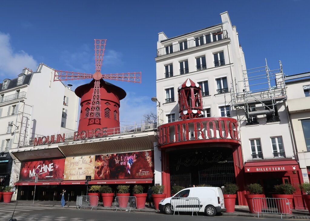 De gevel van de Moulin Rouge overdag met de molen, de ingang van Féerie en de kassa aan de boulevard de Clichy in Parijs