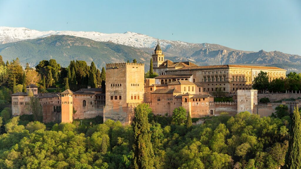 Het Alhambra in Granada gezien vanaf de Mirador de San Nicolás, met de besneeuwde Sierra Nevada erachter