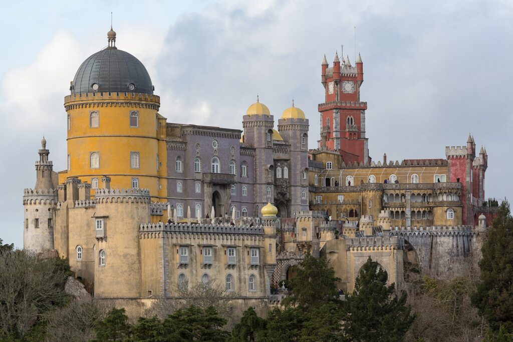 Het Pena-paleis in Sintra met gele en rode torens boven het bos