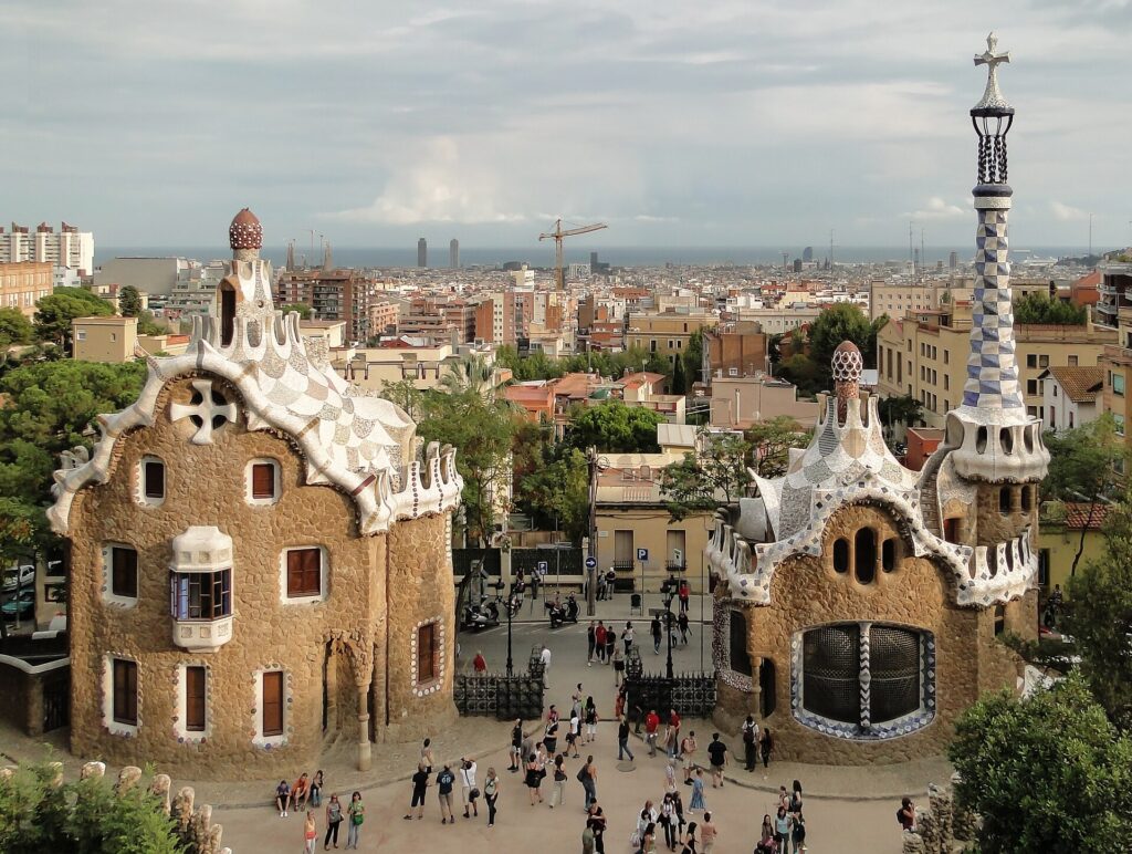 The two entrance pavilions of Park Güell seen from above, with Barcelona behind