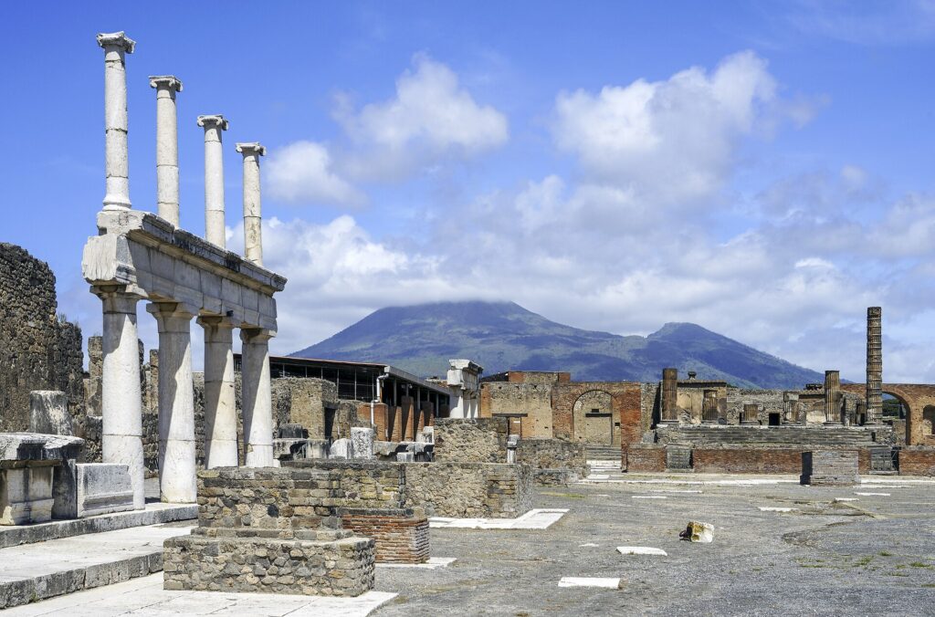 The Forum of Pompeii with ruined columns and Mount Vesuvius in the background