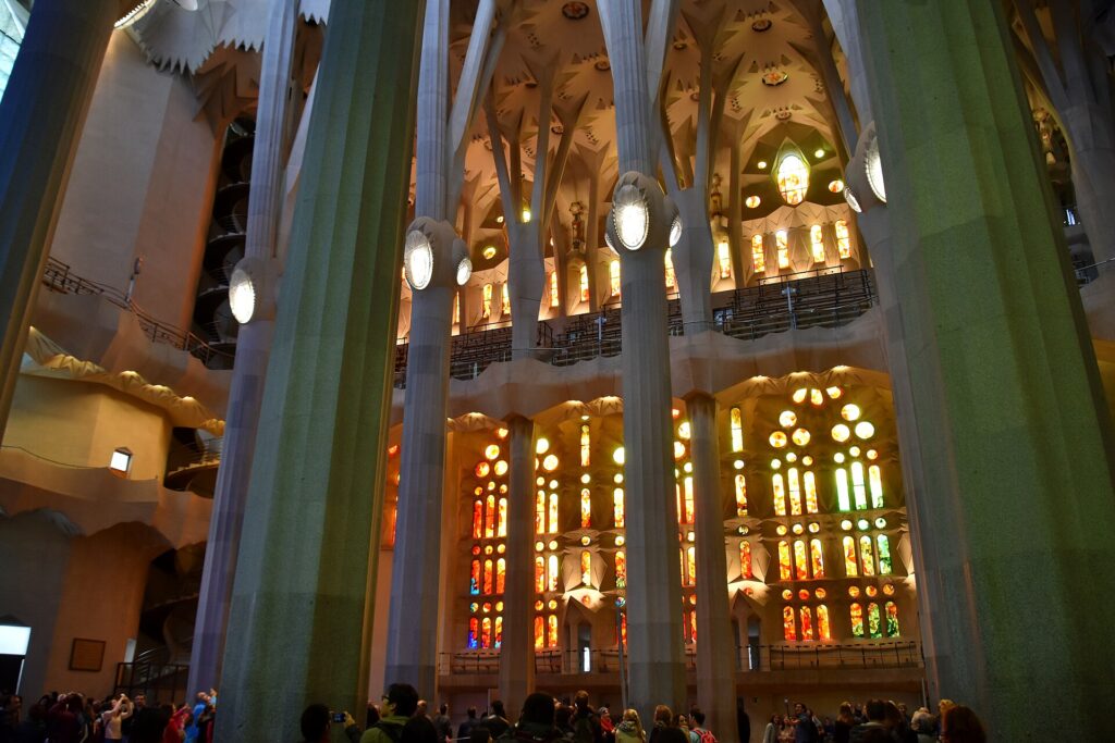 Warm-coloured stained glass windows lighting the nave of the Sagrada Família
