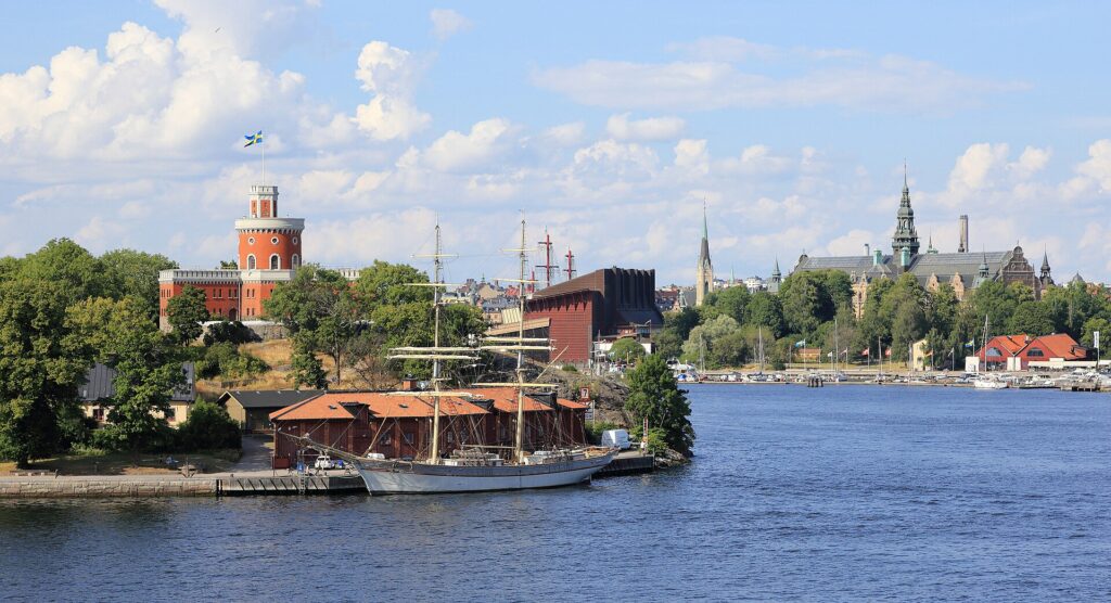 Vasa Museum building with its masts on Djurgården seen across the water with Kastellet and the Nordic Museum