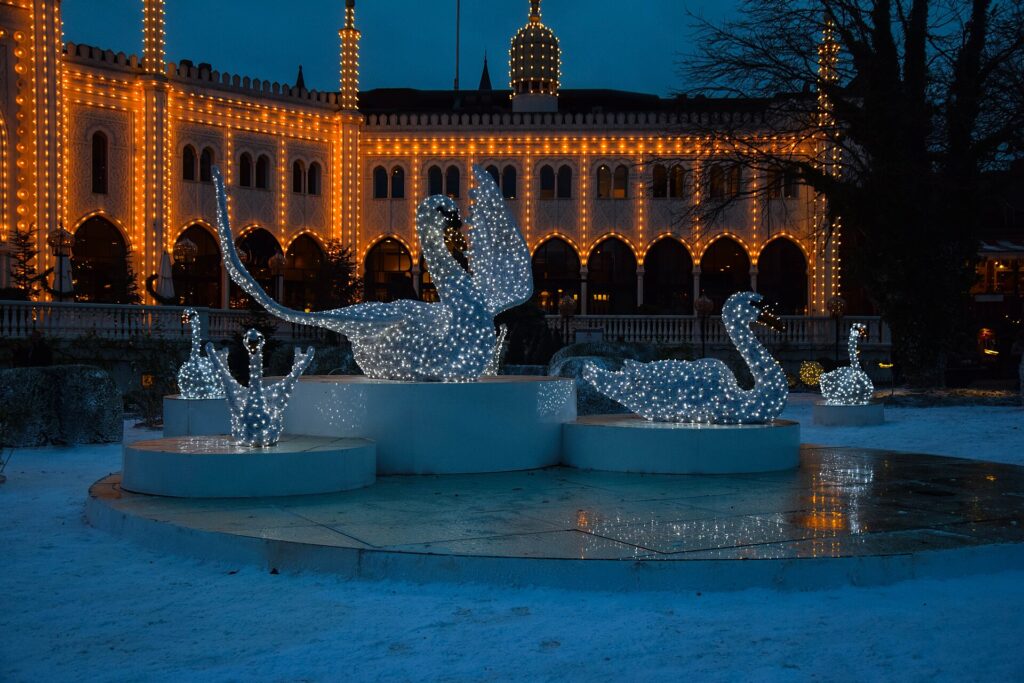 Light sculptures in front of the illuminated Nimb building during Christmas in Tivoli Gardens, Copenhagen