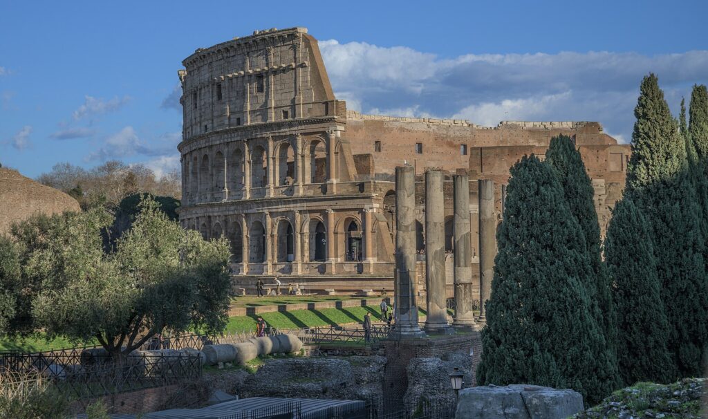 Das Kolosseum vom Forum Romanum aus gesehen, mit antiken Säulen und Zypressen