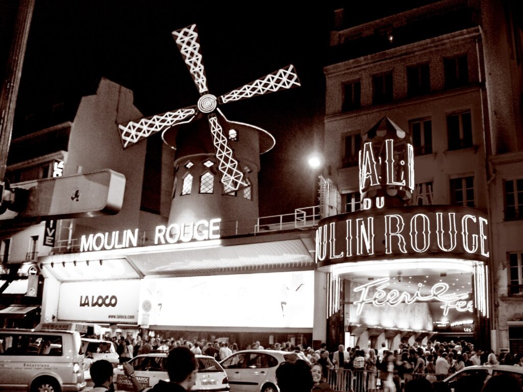 Showbesucher versammeln sich vor einer Abendvorstellung vor dem Moulin Rouge in Paris