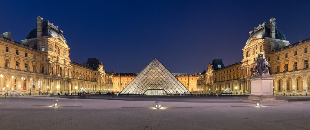 Die Louvre-Pyramide und der beleuchtete Cour Napoléon des Louvre-Museums in der Abenddämmerung