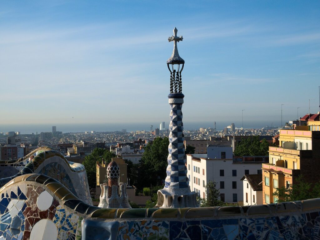 Mosaik-Schlangenbank auf dem Naturplatz im Park Güell mit Blick über Barcelona bis zum Meer