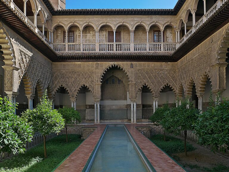 Patio de las Doncellas im Real Alcázar von Sevilla mit langem Wasserbecken, Orangenbäumen und geschnitzten Bögen
