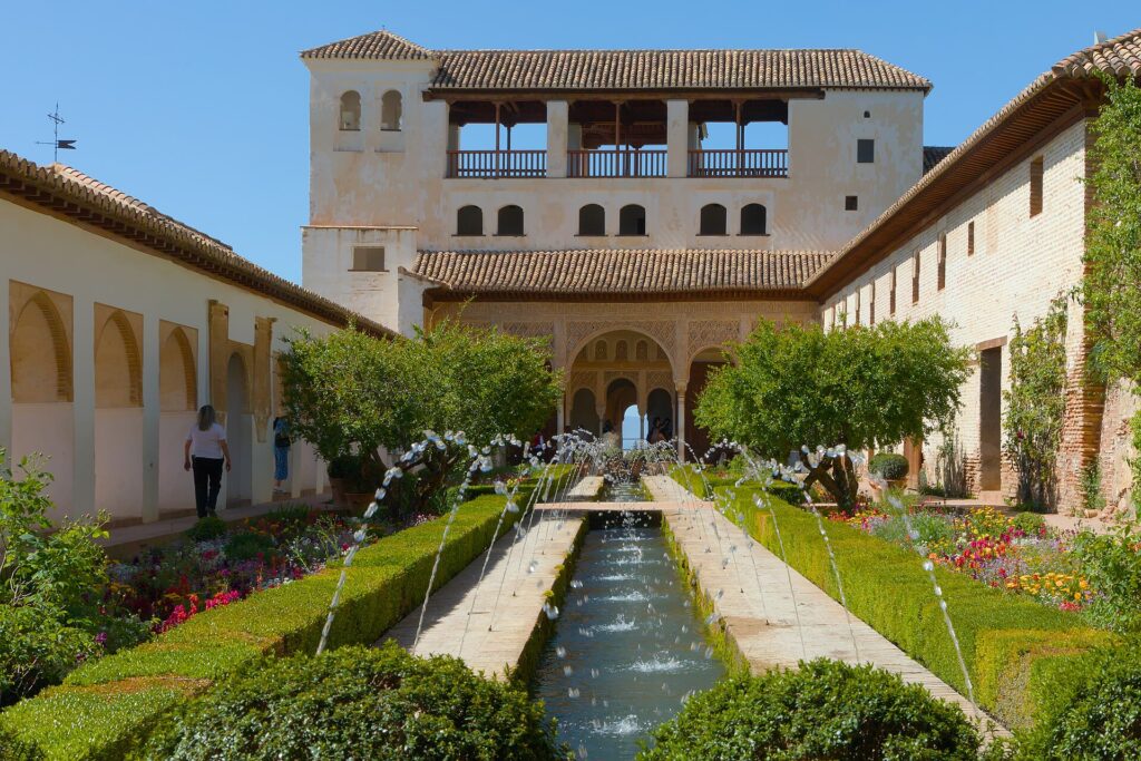Brunnen und Blumenbeete am Patio de la Acequia in den Gärten des Generalife der Alhambra