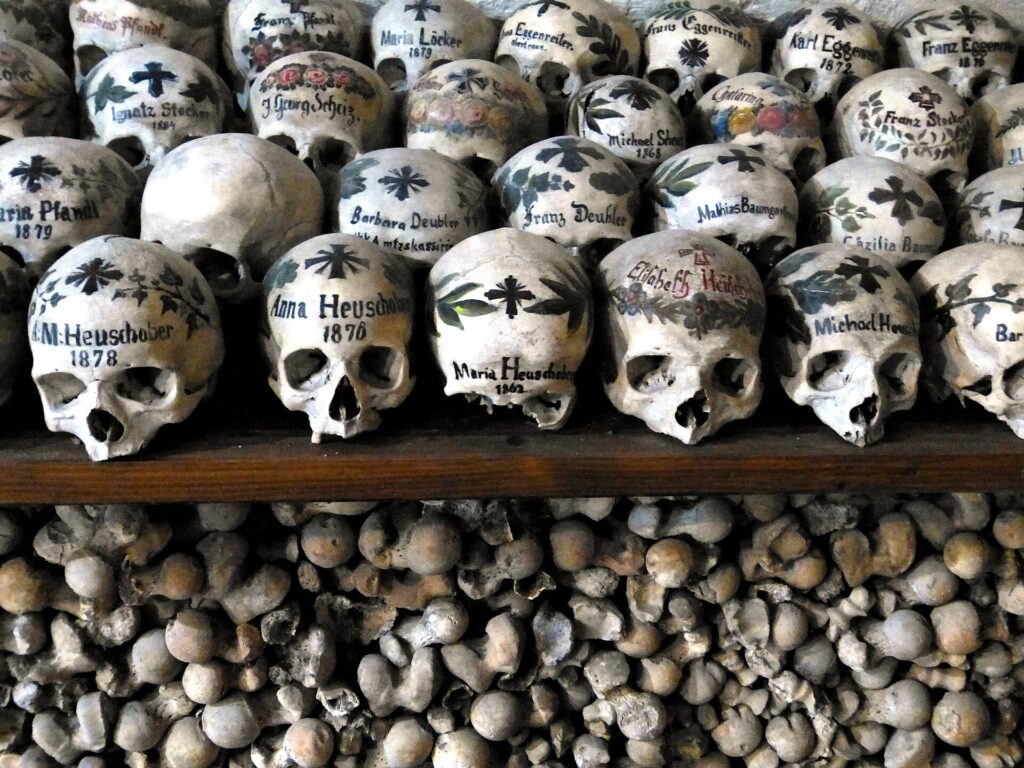Bemalte Schädel mit Namen und Blumen im Beinhaus von Hallstatt