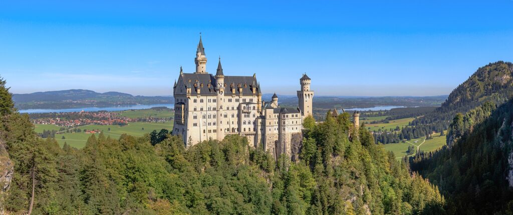 Schloss Neuschwanstein auf seinem bewaldeten Felsgrat über den Seen und der Landschaft des Allgäus
