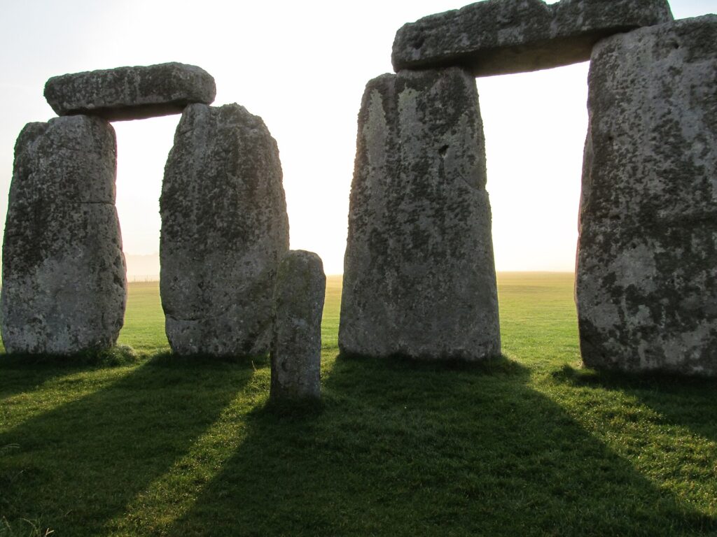Tief stehende Morgensonne wirft lange Schatten durch die Sarsensteine von Stonehenge