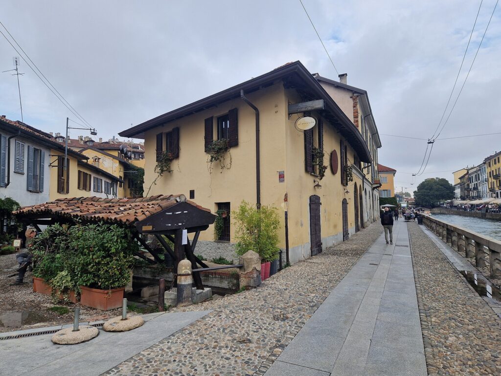 Kopfsteingepflasterte Uferstraße am Naviglio Grande in Mailand mit überdachtem Waschhaus