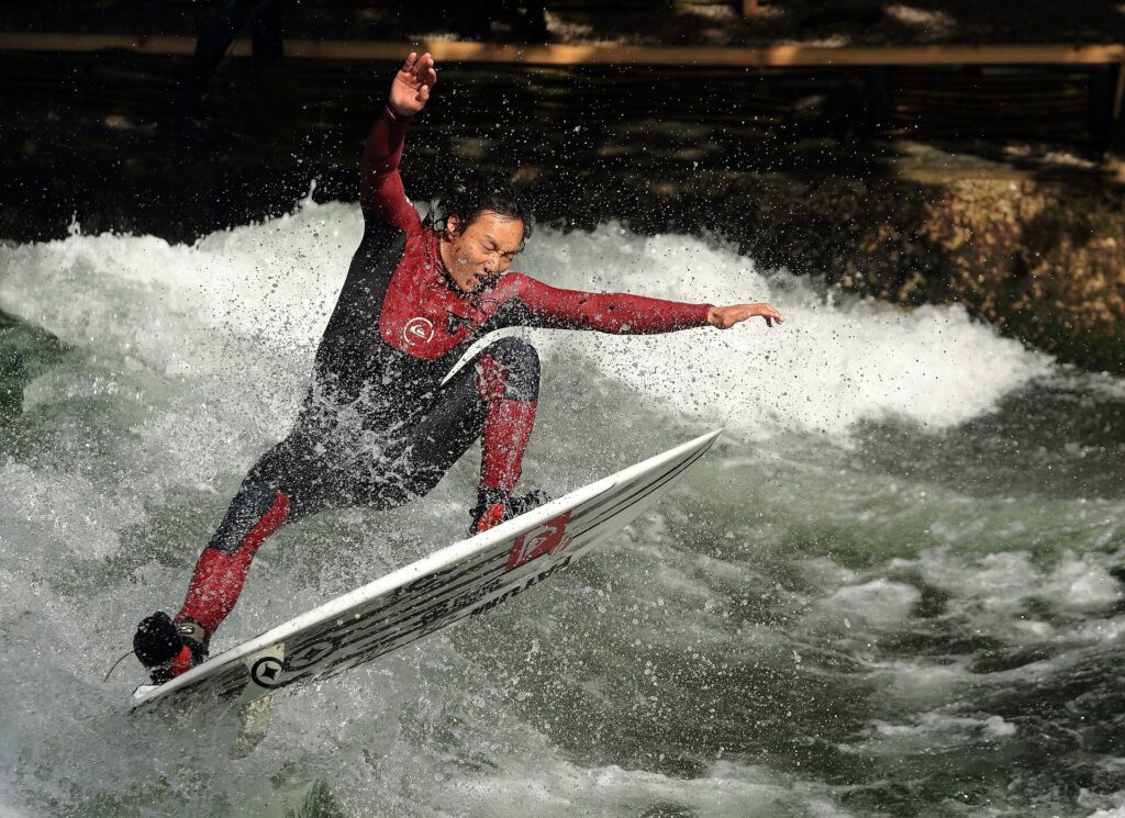 Surfer auf der stehenden Welle des Eisbachs im Englischen Garten, München
