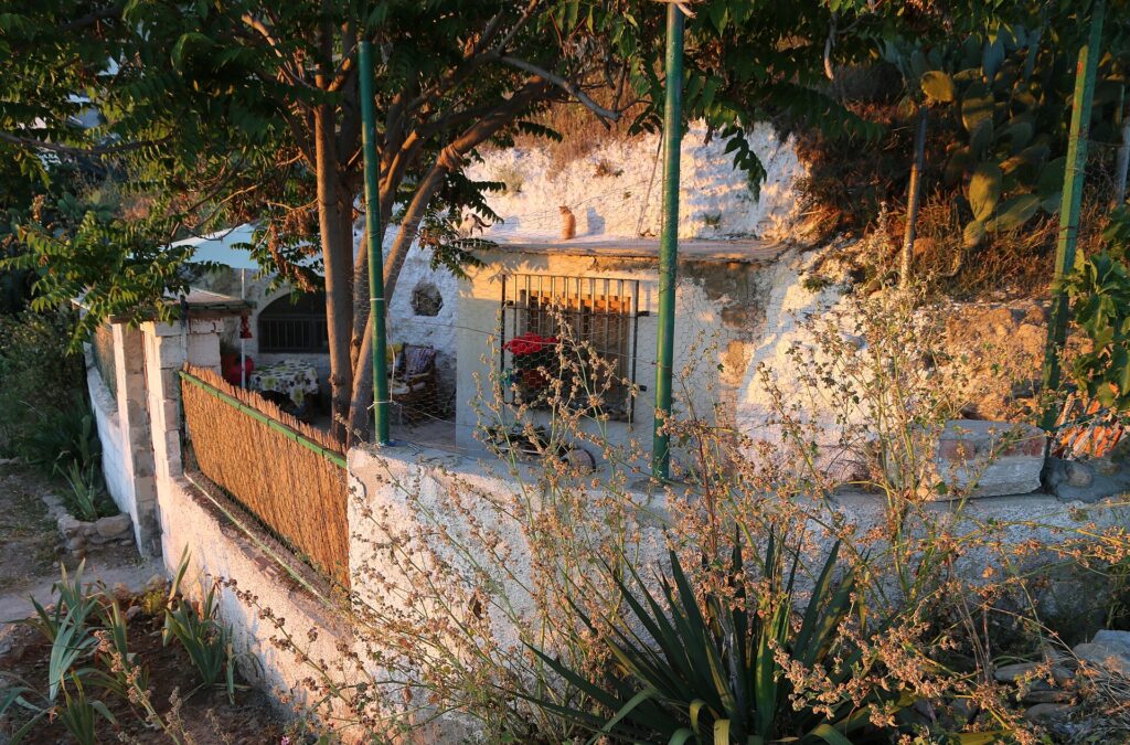 A whitewashed cave house with a small garden on the hillside of Sacromonte in Granada