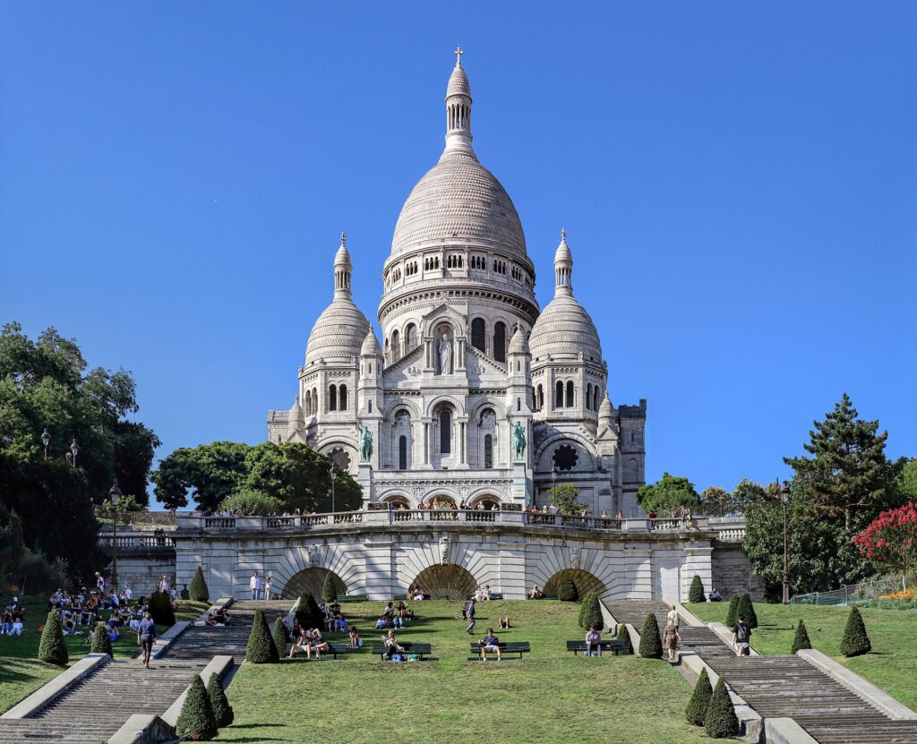 The white Basilica of Sacré-Cœur on the hill of Montmartre in Paris under a blue sky